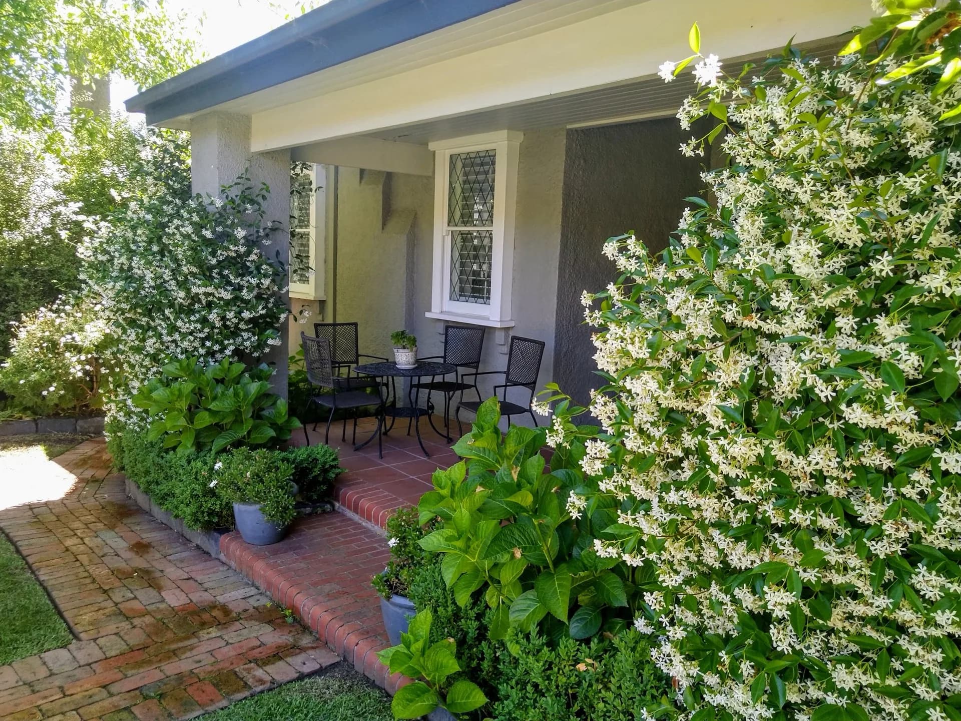 Charming cottage verandah with star jasmine and manicured garden entry